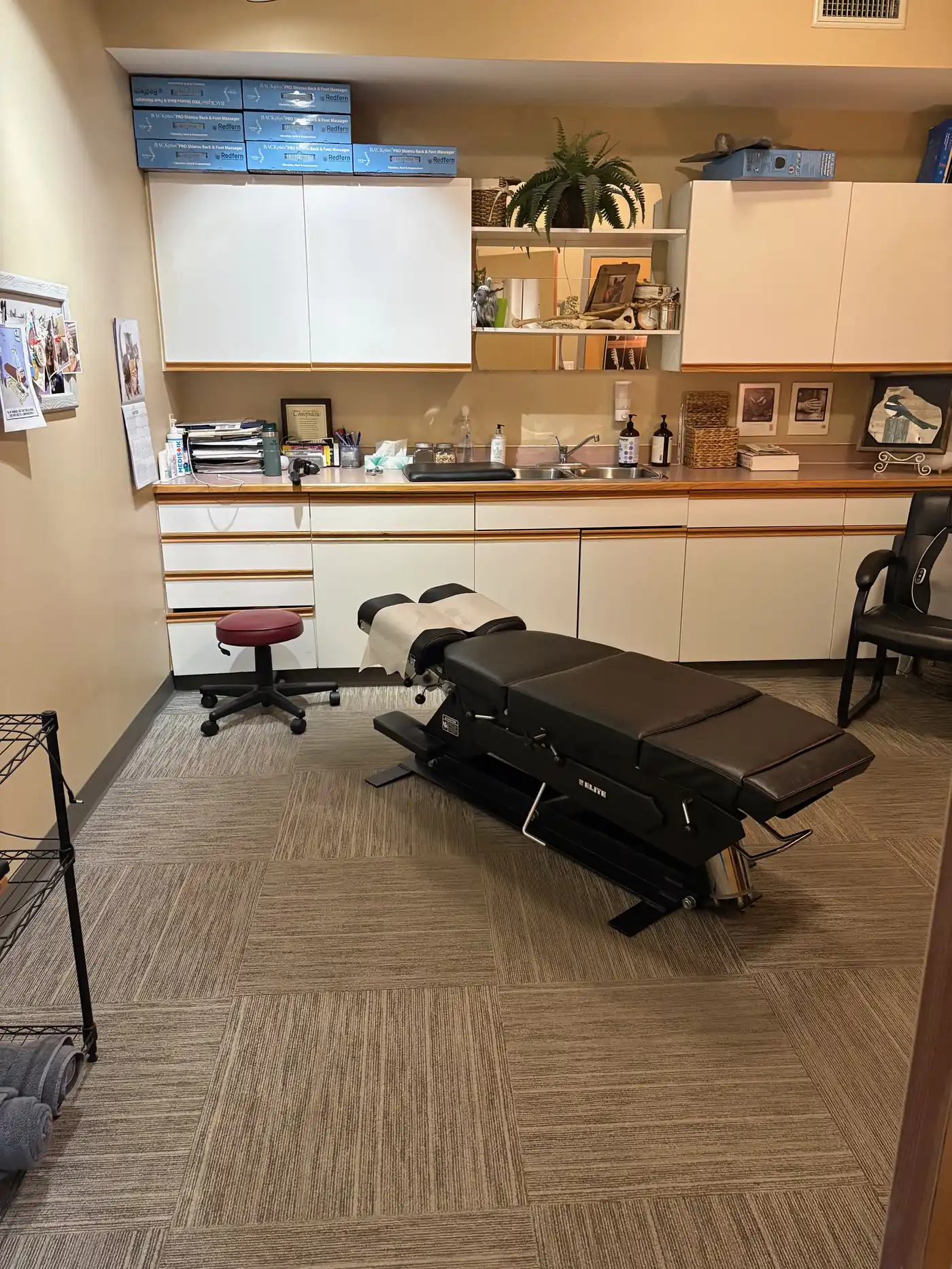 A clean, professional treatment room at Okanagan Chiropractic Center in Penticton with a chiropractic adjustment table